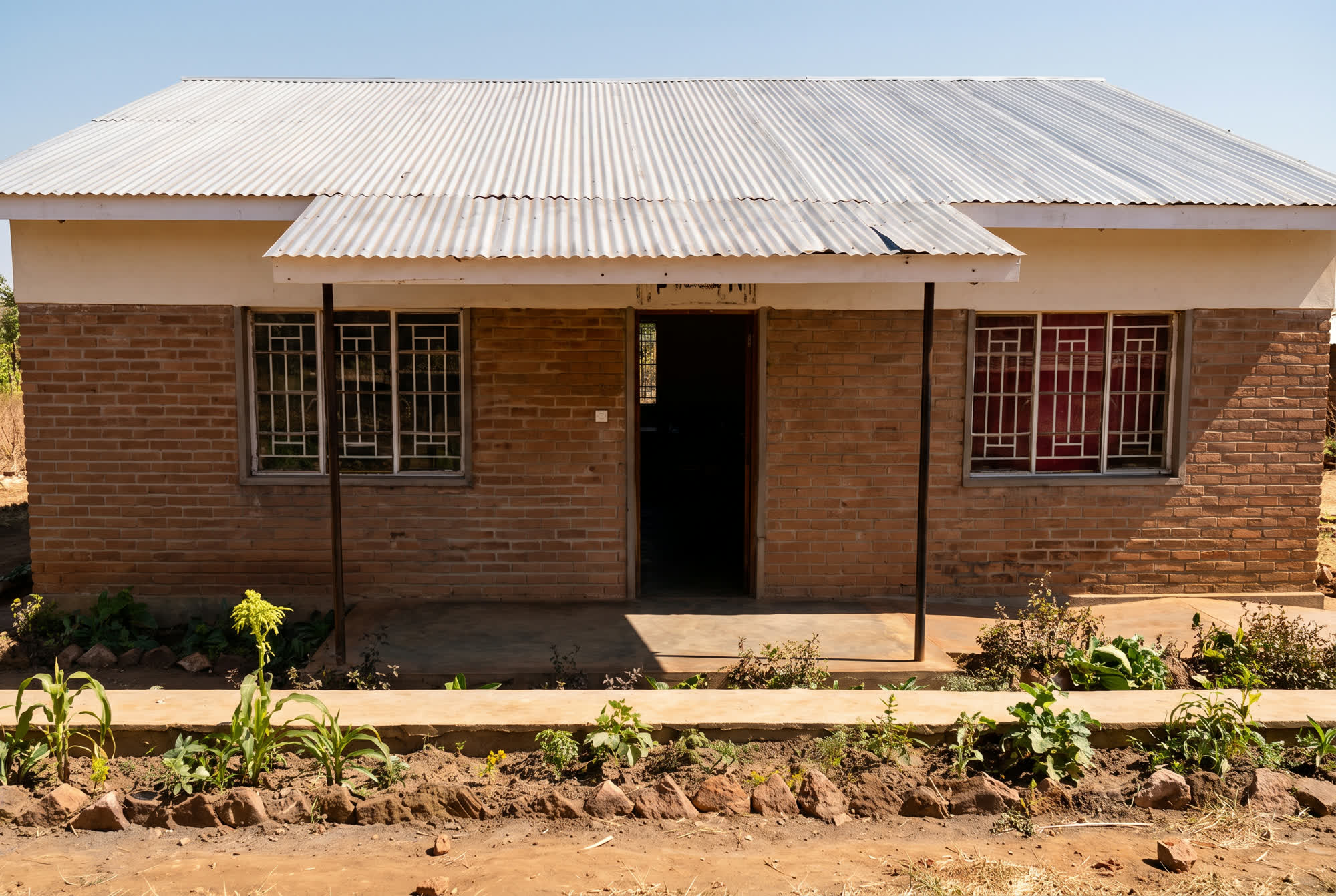 KI-generierte Darstellung eines Ziegelhauses mit Wellblechdach und vergitterten Fenstern in Malawi